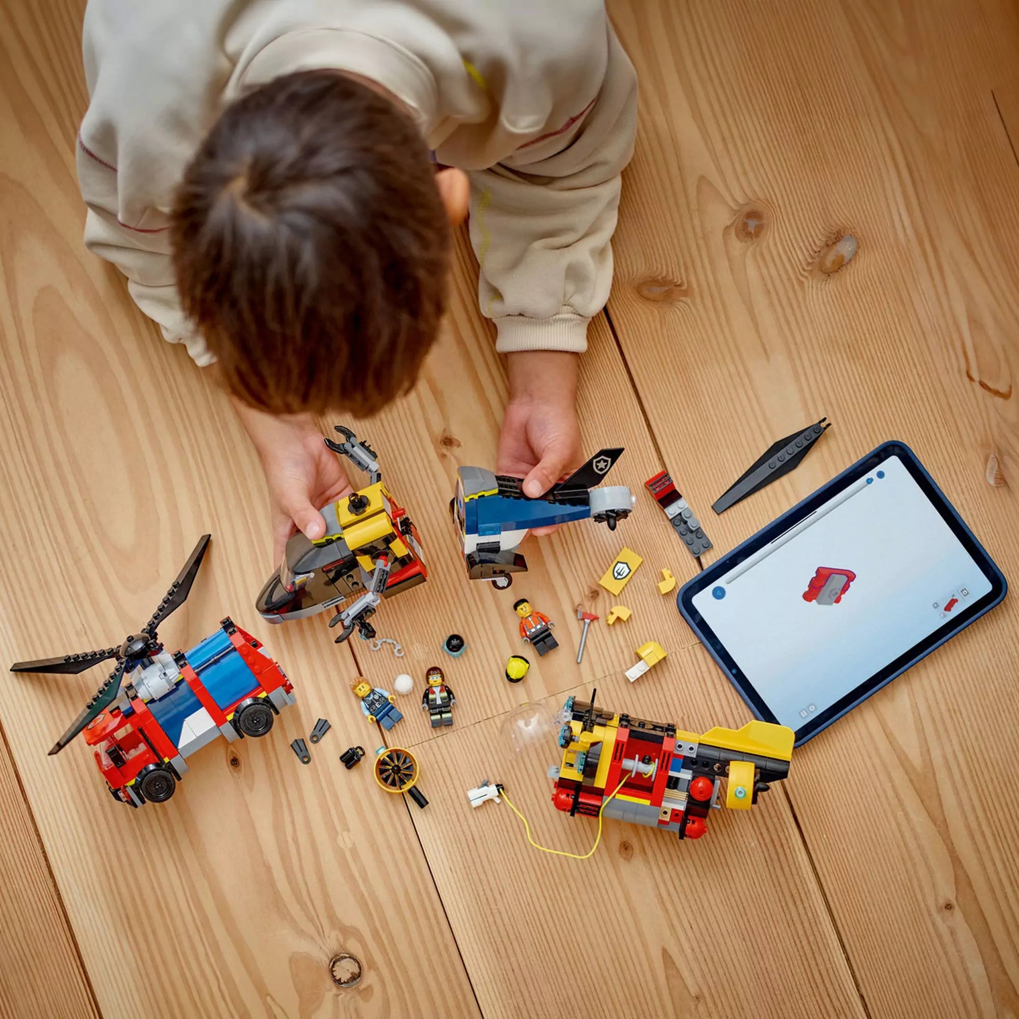  Gyerek építi a LEGO City Helikopter, tűzoltóautó és tengeralattjáró modellt a LEGO Builder app segítségével.