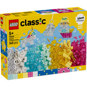 Ez a kép a LEGO Classic Átlátszó bűvös kockák (11040) készlet dobozát mutatja. A doboz színes és vidám dizájnnal rendelkezik, amely kiemeli a készletben található 340 darab átlátszó és színes építőkockát. A borítón néhány kreatív építmény is látható, például egy unikornis kastély, egy aranyos kulcstartó és egy vidám hajós figura, amelyek inspirációként szolgálnak az építéshez. Az ajánlott életkor 5 éves kortól, és a szett remek lehetőséget biztosít a kreativitás kibontakoztatására.