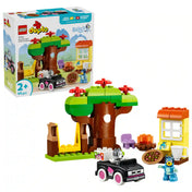 LEGO DUPLO Bluey: Pizza parti Muffinnal és Bluey-val (10469) készlet a dobozképpel együtt, nagy faépítménnyel, hintával, pizzával, házrésszel, autóval és Bluey, valamint Muffin figurákkal.
