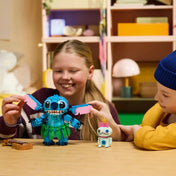LEGO Disney Stitch és Scrump (43296) készlet játék közben, ahol a gyerekek a megépíthető Stitch figura mozgatható füleit állítják, mellette Scrump baba és ukulele látható.