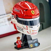 LEGO Editions Scuderia Ferrari HP Charles Leclerc sisakja 43014, 886 darabos készlet kiállítva, talapzaton minifigurával.