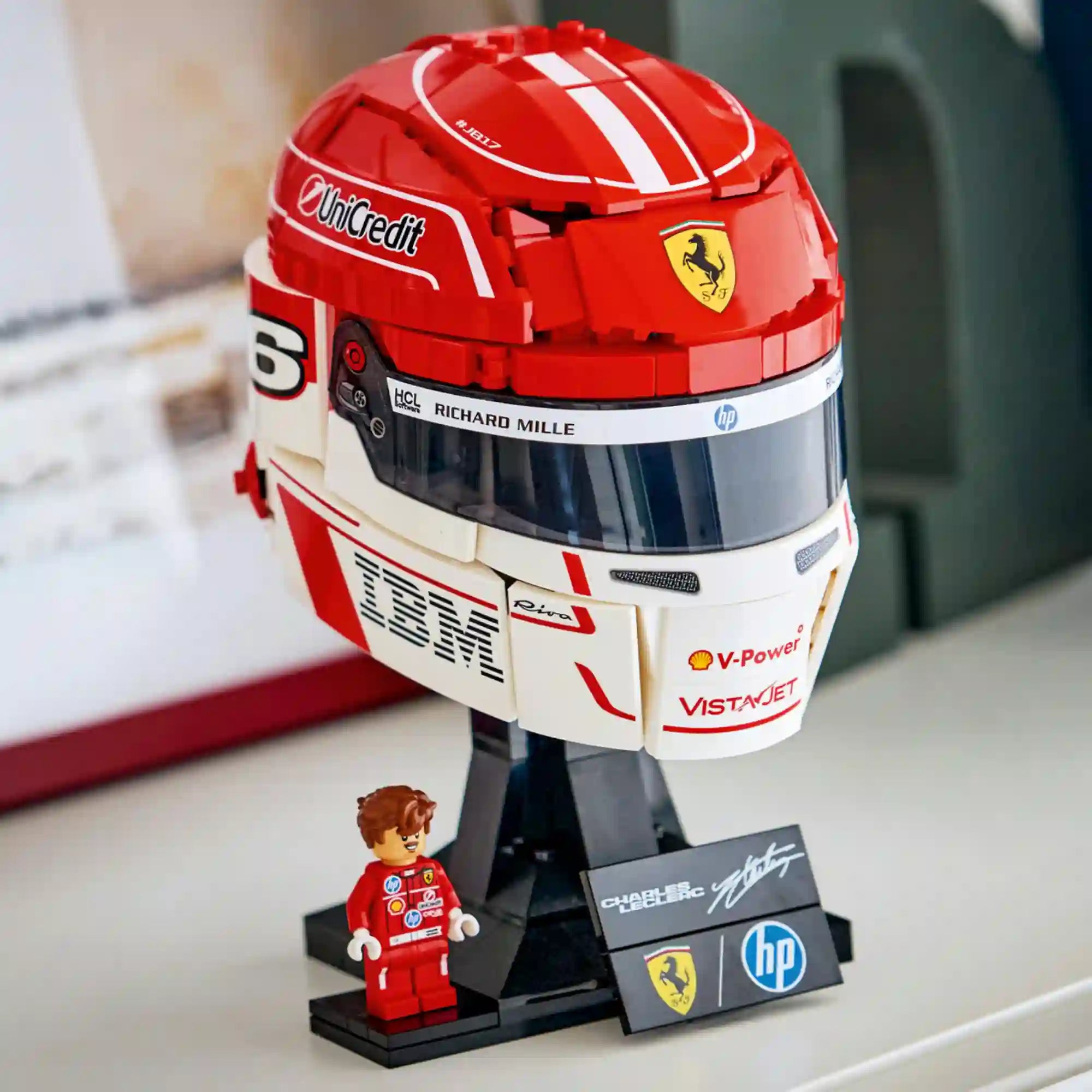 LEGO Editions Scuderia Ferrari HP Charles Leclerc sisakja 43014, 886 darabos készlet kiállítva, talapzaton minifigurával.