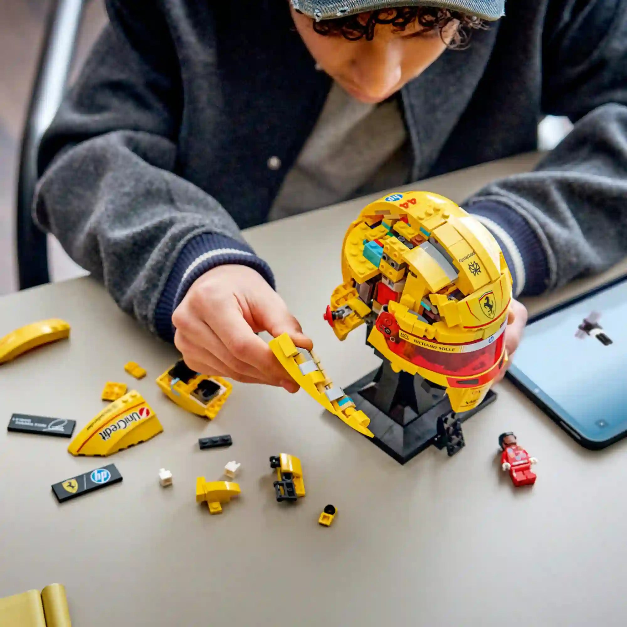 LEGO Editions Scuderia Ferrari HP Lewis Hamilton sisakja 43022, 884 darabos készlet építés közben, szétszedett elemekkel és minifigurával.