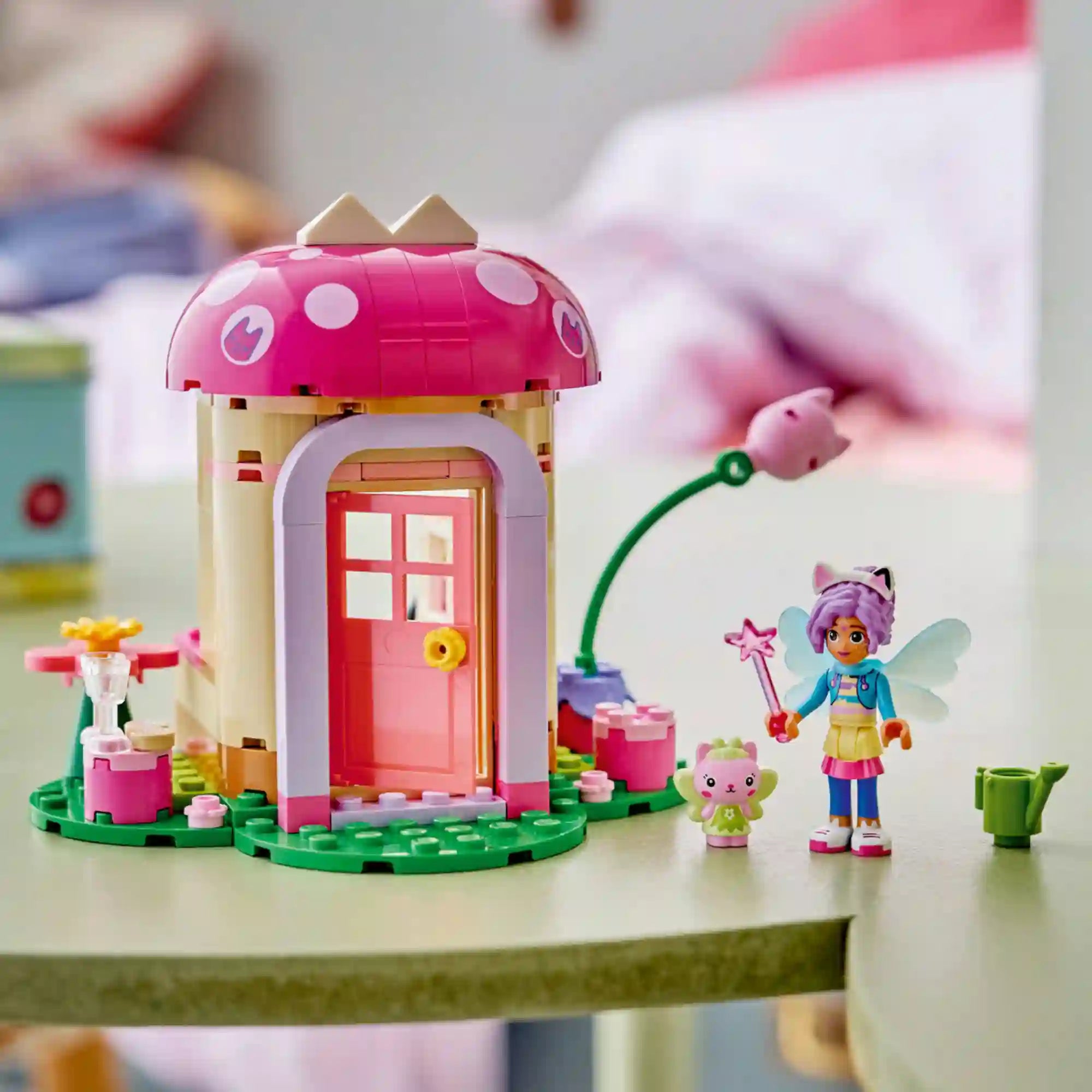 LEGO Gabby babaháza 11212 Kitty Tündér kerti háza megépített modellje játék közben, Kitty Tündér minibaba figurával, kiscica karakterrel és varázslatos kerti kiegészítőkkel.