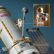 A LEGO Icons Hubble Űrteleszkóp 11382 közelképe az űrhajós minifiguráról és a teleszkóp részletgazdag külső elemeiről.