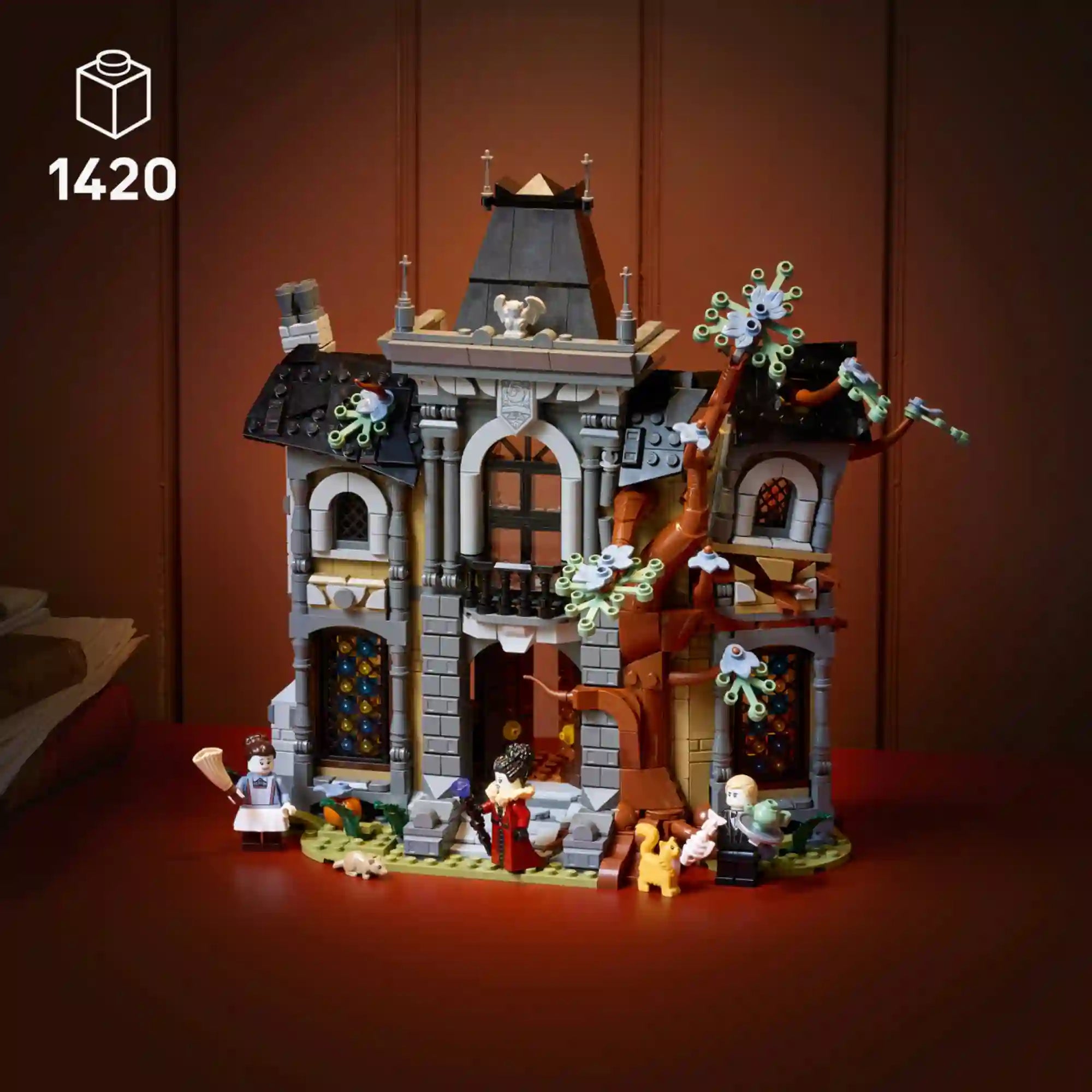LEGO Icons 11383 Mayor Manor szürke, gótikus kastélymodellje fekete tetővel, kopár fával és három minifigurával.