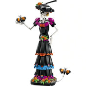 A LEGO Ideas La Catrina 21372 megépített La Catrina figurája fekete ruhában, virágdíszekkel és egy díszes méhecskével.