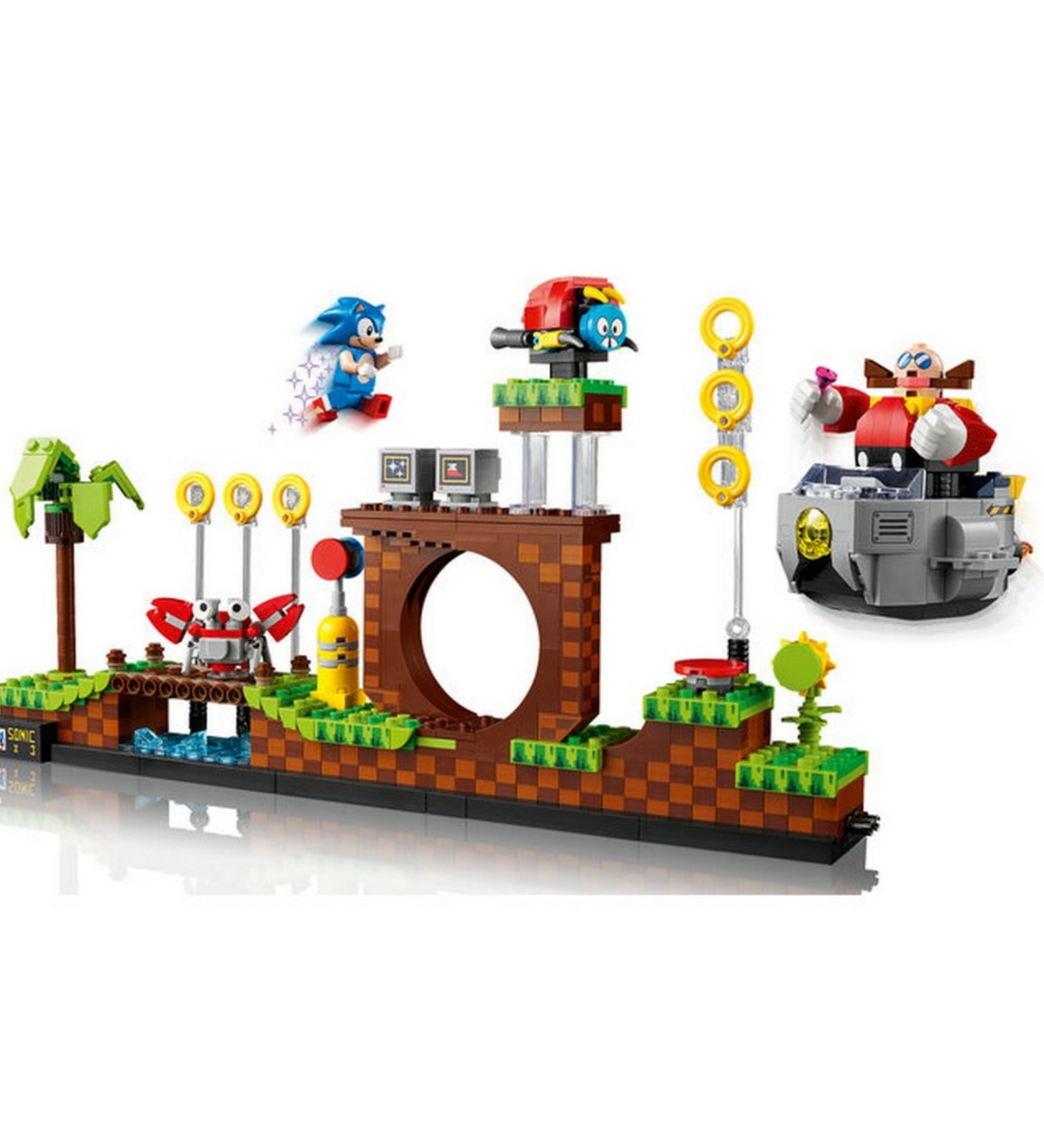 Akcióban ábrázolt LEGO 21331-es Sonic the Hedgehog készlet, amelyen Sonic éppen a levegőben száguld, miközben Dr. Eggman, motobug és egyéb klasszikus játékbeli elemek jelennek meg.