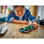 LEGO Speed Champions Aston Martin Aramco F1 AMR24 versenyautó 77245, lány játszik a versenyautóval mosolyogva.