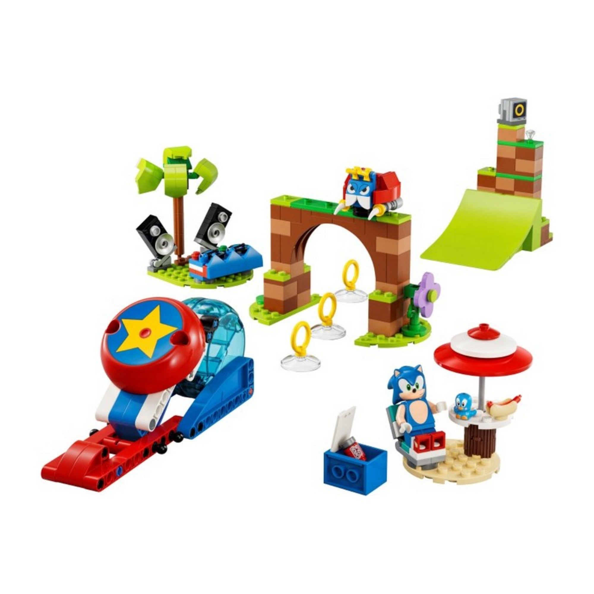 A képen a LEGO Sonic the Hedgehog – Sonic’s Speed Sphere Challenge (76990) készlet egyes elemei láthatók részletesen, összeépítve. A középpontban egy barna-zöld árkádos kapu szerepel, amely alatt három aranygyűrű található – ezek Sonic ikonikus gyűrűi. A kapu tetején egy piros-sárga robot madár helyezkedik el. Jobbra egy zöld rámpa áll, amelyet Sonic sebességgömbje használhat ugratásra.Bal oldalon egy piros-kék kilövő szerkezet található, nagy sárga csillaggal a tetején, mellette pedig egy kis pihenőhely.