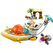 Összerakott LEGO szett motorcsónakkal, benne Tails figurájával, Sonic vízisízés közben a hajó mögött, a háttérben pálmafa, gyűrűs kapu és kiegészítők.