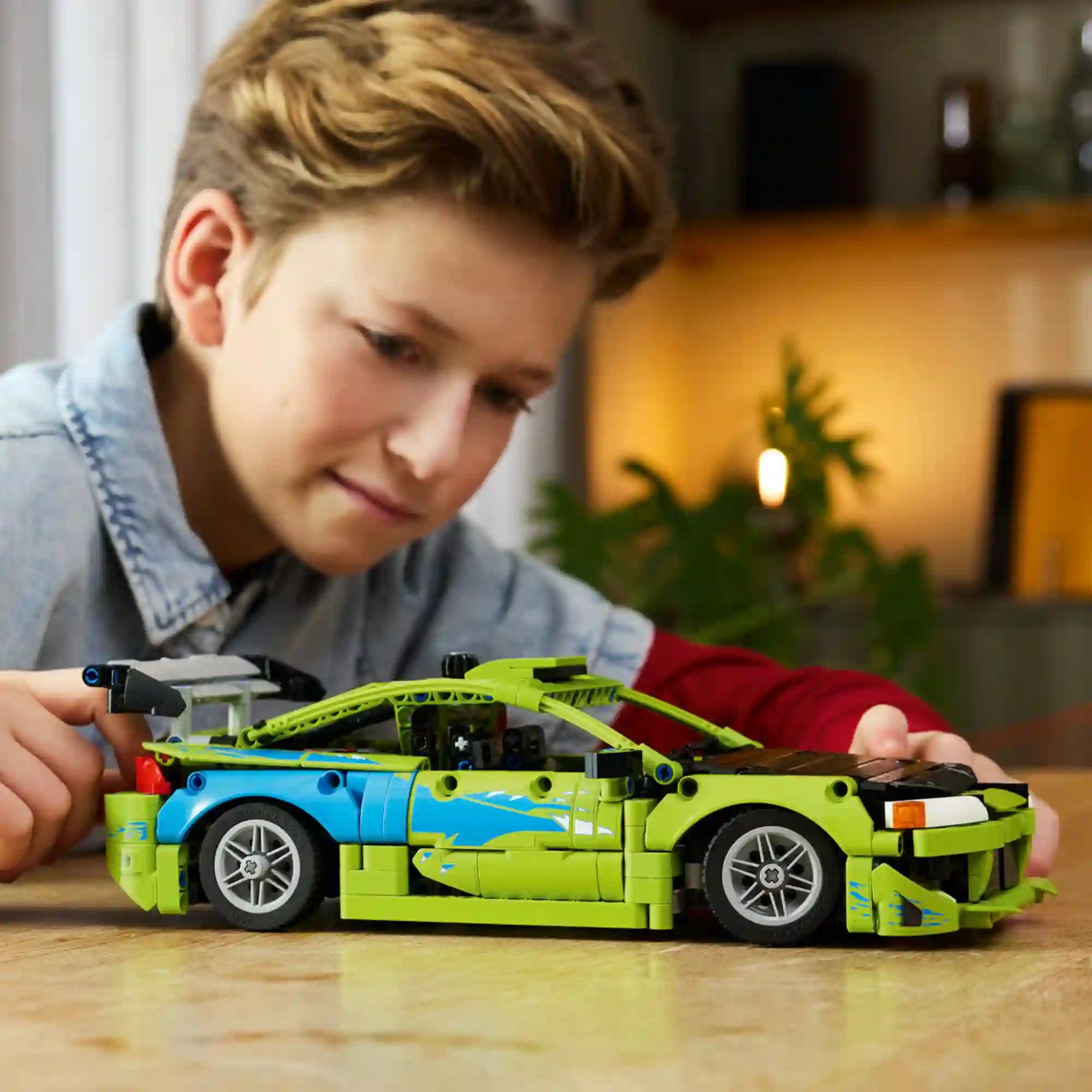 LEGO Technic Fast & Furious Mitsubishi Eclipse (42229) megépített modell játék közben, ahol egy fiatal rajongó a részletgazdag versenyautót vizsgálja egy asztalon.