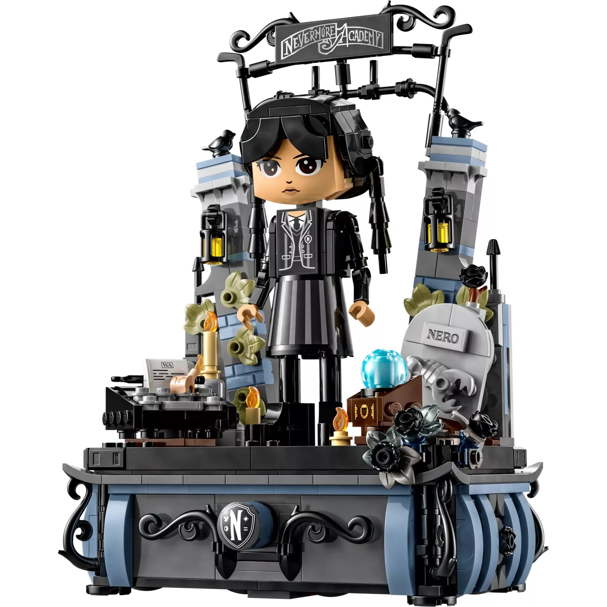 A LEGO Wednesday Addams figura részletesen, a Nevermore Akadémia felirattal és a kiegészítőkkel, például gyertyákkal, fekete virágokkal és egy sírkővel.