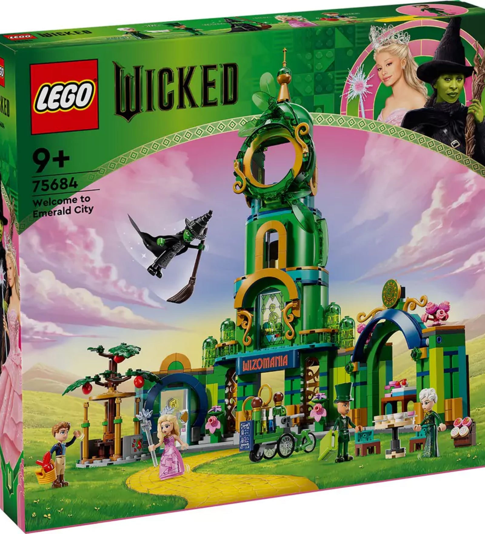 A LEGO Wicked – Köszöntünk Emerald Cityben (75684) készlet színes díszdoboza, rajta a zöld tornyos építmény, több karakterfigura és a seprűn repülő boszorkány illusztrációja, rózsaszín égbolt hátterében.