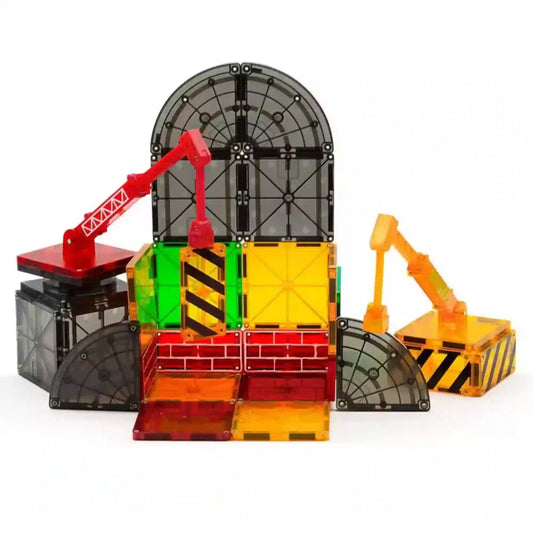 MAGNA-TILES Builder 32 darabos mágneses építőkészletből készült építkezési helyszín, két daruval és színes építőelemekkel.