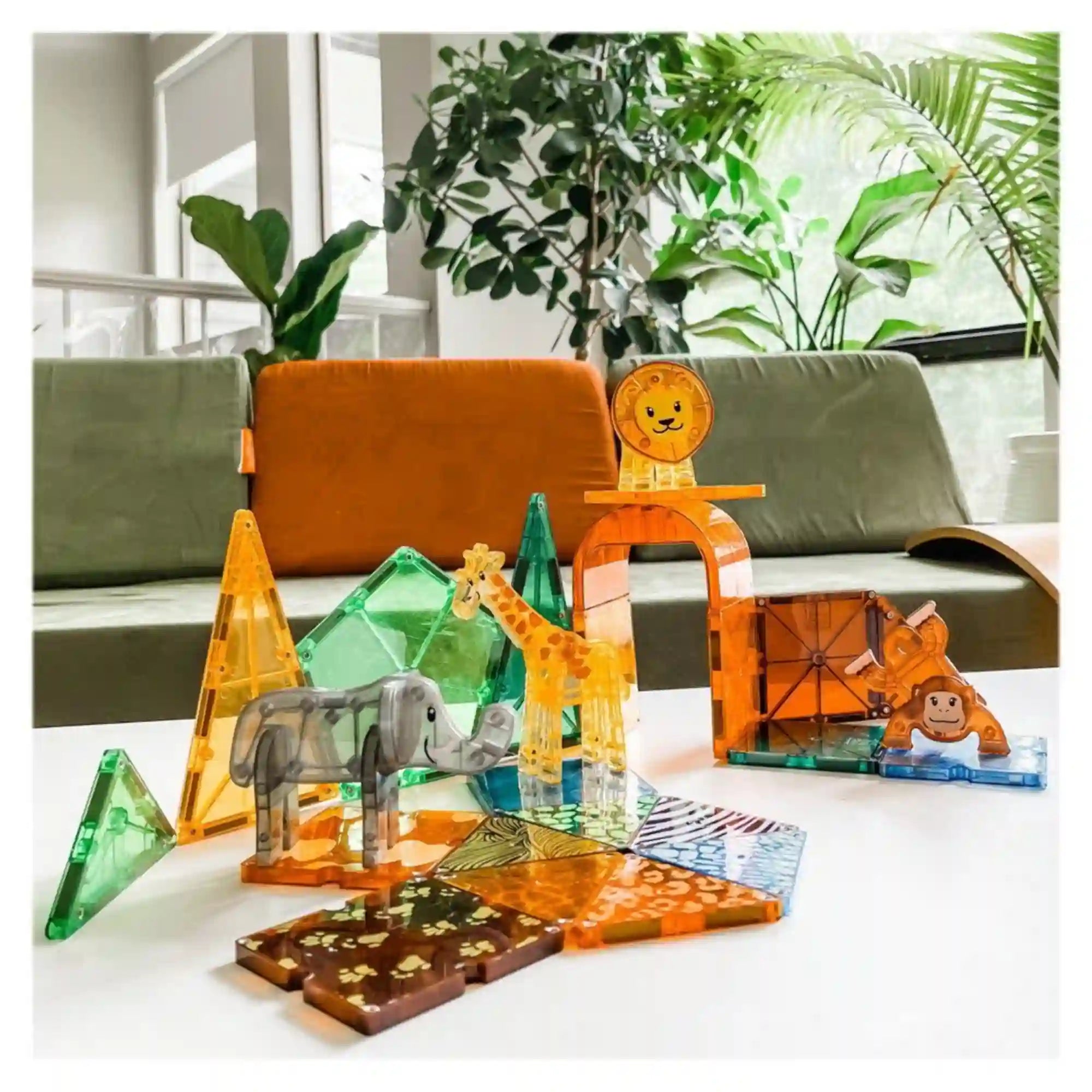 MAGNA-TILES Safari Animals mágneses építőkészletből készült szafari jelenet egy asztalon, elefánttal, zsiráffal, oroszlánnal és majommal.