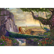 A képen a Schmidt Puzzle – The Lion King: Return to Pride Rock kirakó teljes képe látható. Thomas Kinkade varázslatos illusztrációja eleveníti meg az Oroszlánkirály ikonikus jelenetét: Simba büszkén áll a Szikla ormán, míg körülötte színes növényzet, vízesés, állatok és a naplementében fürdő táj teszi teljessé az epikus pillanatot.