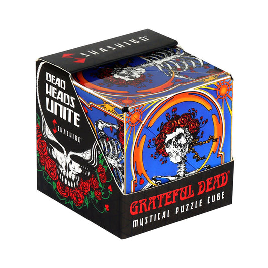 A Shashibo: Skull & Roses mágneses átalakítható kocka doboza, a Grateful Dead híres koponya és rózsás motívumával díszítve, élénk kék és narancssárga háttérrel, fekete alapon piros rózsákkal és „Dead Heads Unite” felirattal.