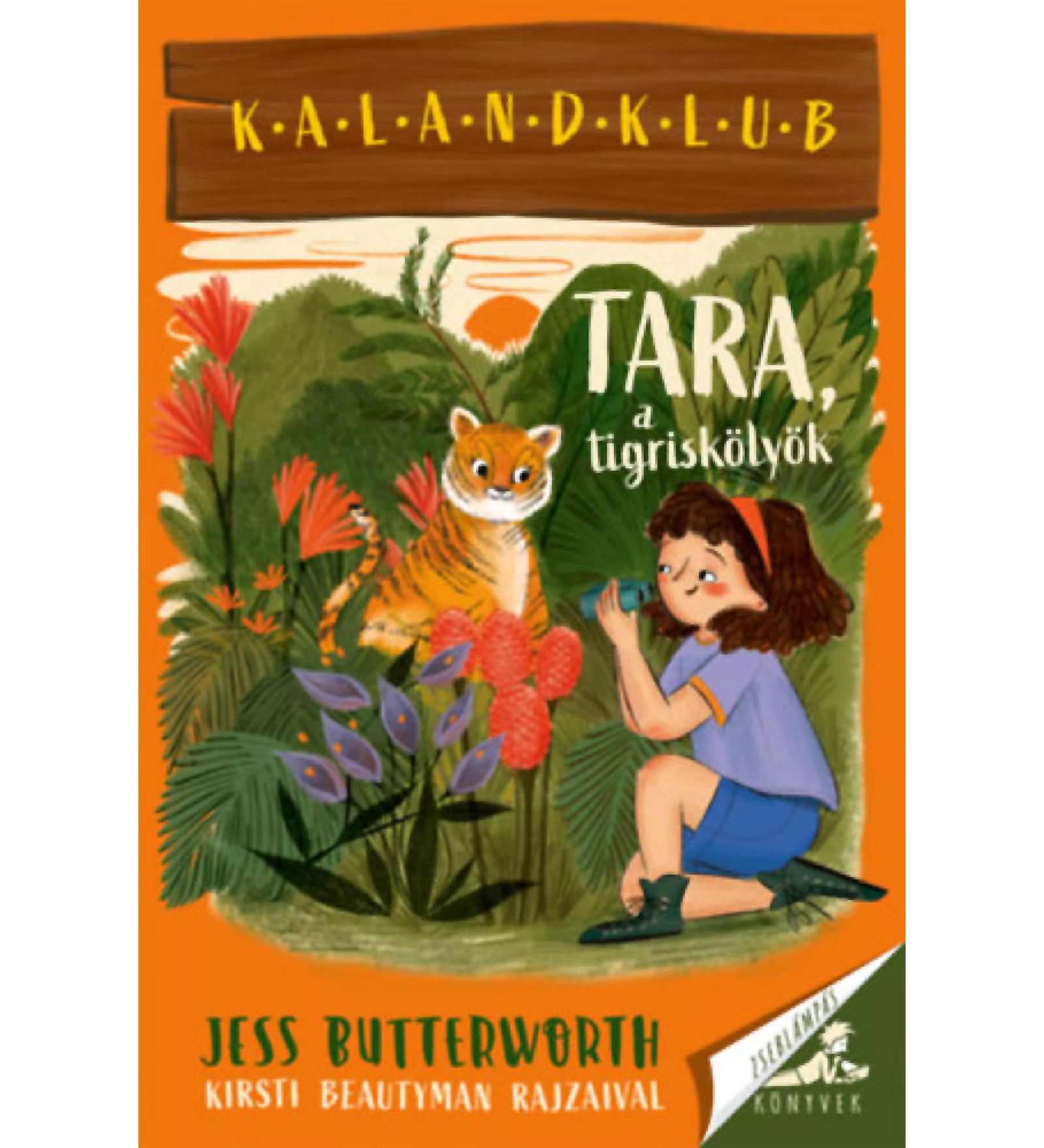 Tara, a tigriskölyök” könyvborító, egy kislány dzsungelben fotóz egy tigriskölyköt, színes növények és naplemente háttér előtt.