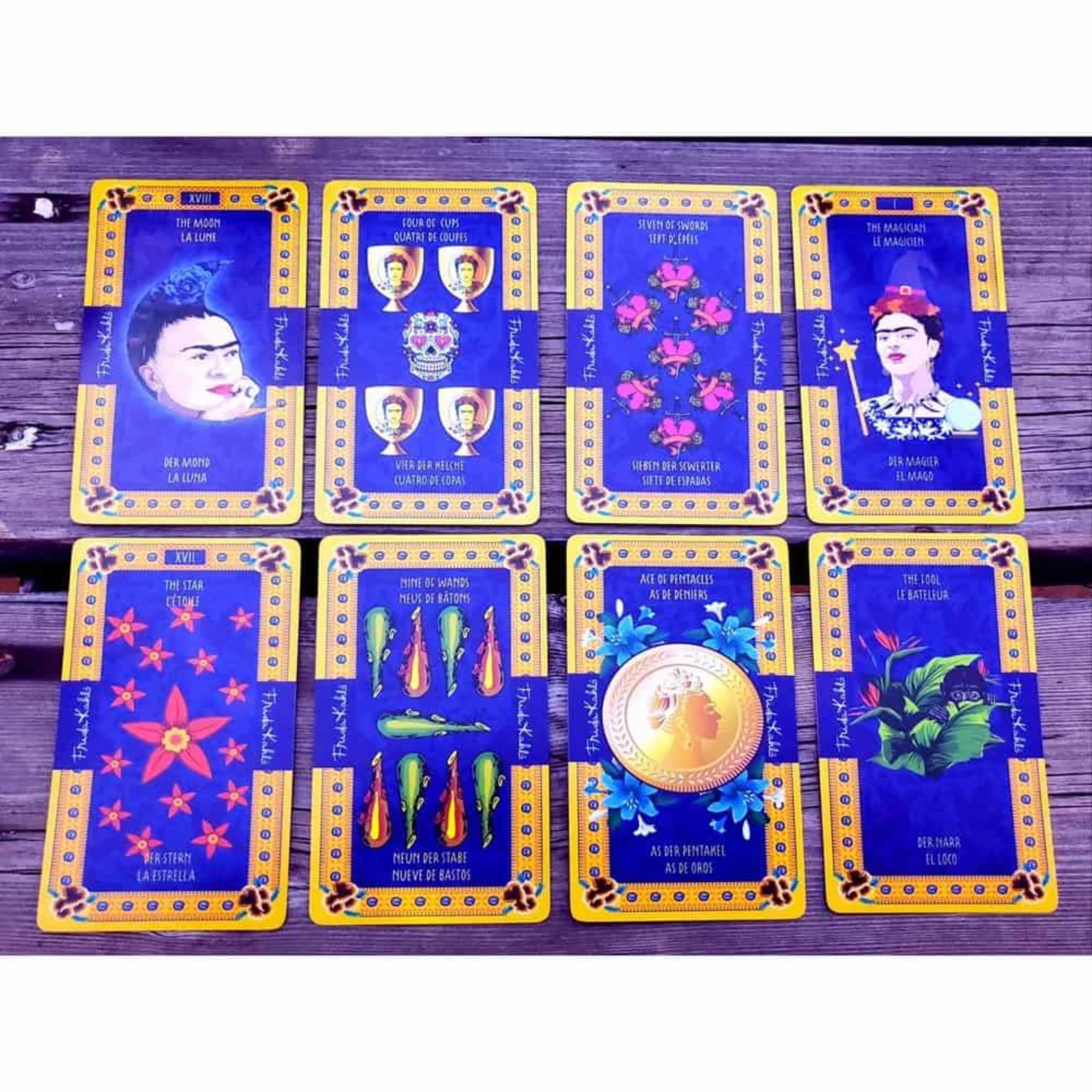 A képen a Frida Kahlo Tarot kártyacsomag egy válogatott lapjai láthatók, színes és gazdagon díszített dizájnnal. A kártyák domináns színe a mélykék és arany, amelyet virágminták és mexikói népművészeti motívumok egészítenek ki. Több kártyán is megjelenik Frida Kahlo portréja, különböző szimbólumokkal kiegészítve. A „The Magician” és „The Moon” lapokon a festőnő ikonikus arcképe szerepel, míg más lapokon paprikák, virágok, aranyérmék és festmények utalnak Frida életére és művészetére. 