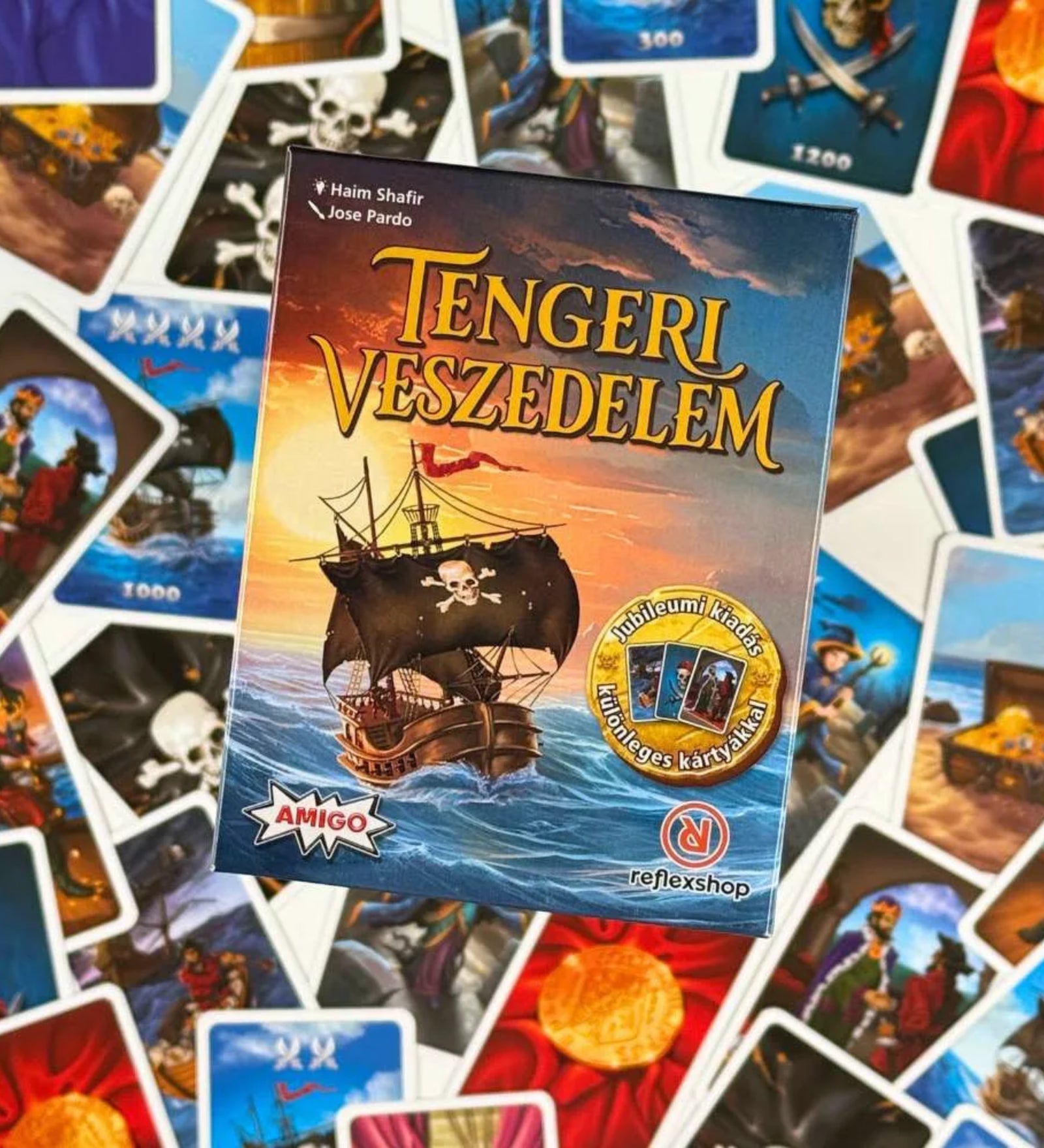 Tengeri Veszedelem magyar nyelvű társasjáték doboza felülről fotózva, körülötte színes kalózos kártyák, hajók, kincsek és tengeri jelenetek illusztrációival.