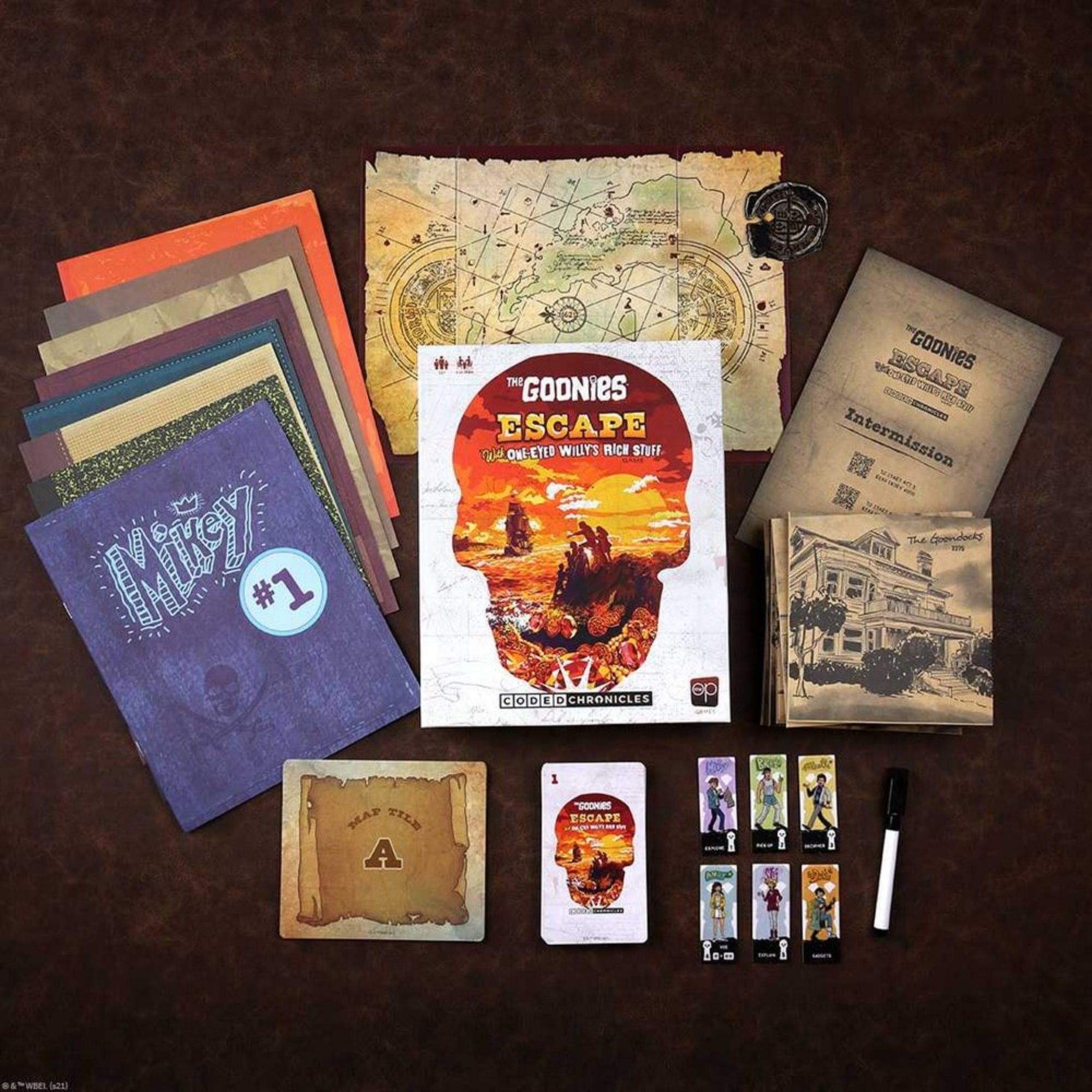 A The Goonies: Escape játék tartalma: kalóztérképek, karakterlapkák, naplók, rejtvények és feladványkártyák szépen elrendezve egy asztalon.