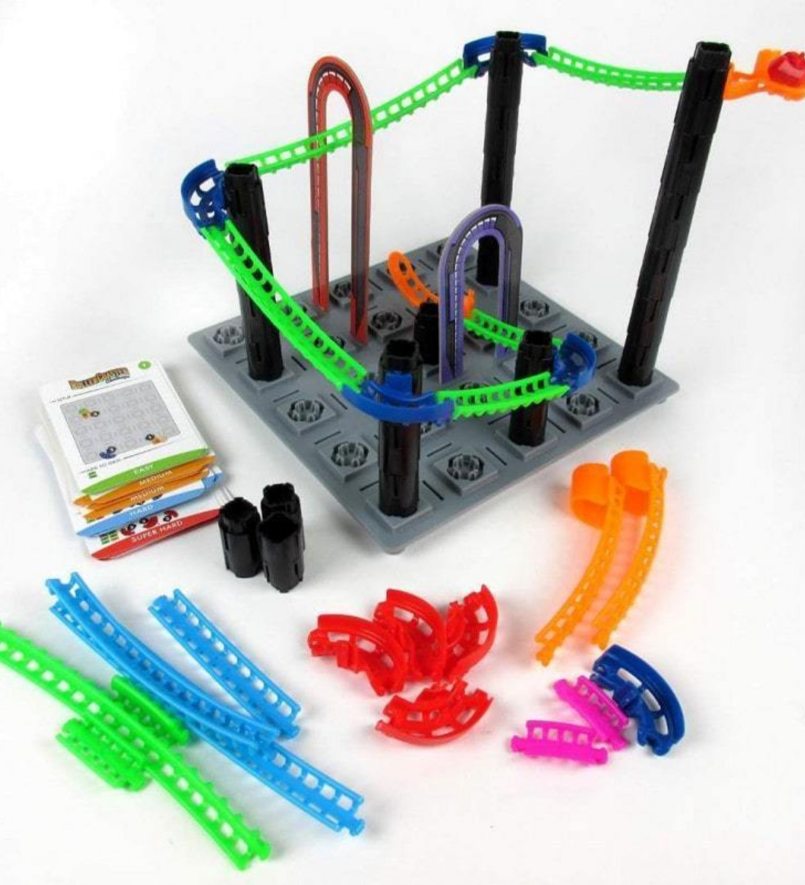 ThinkFun Roller Coaster Challenge játéktartalom: színes pályaelemek, oszlopok, alaplap, kártyák és összeállított hullámvasút részlet.