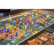 Zugkocsma társasjáték játéktáblája játék közben, színes figurákkal, épületekkel, autóval és pénzérmékkel a 20-as évek hangulatában.