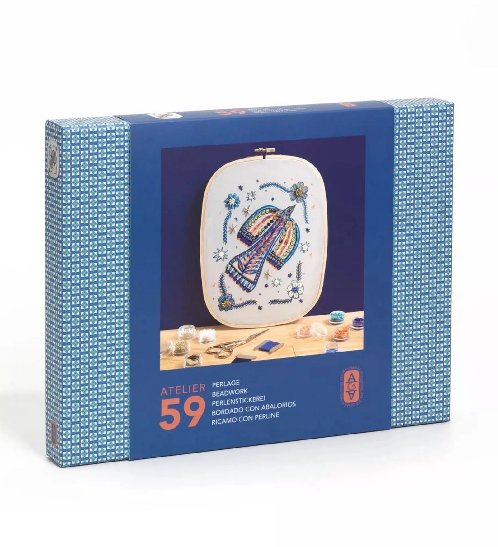 Atelier 59 hímző készlet felnőtteknek: Gyöngymadár – dobozkép: A készlet kék doboza a gyöngyökkel díszített, színes madármintás hímzéssel a középen, körülötte gyöngyök és fonalak.