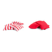 Négy piros-fehér csíkos és négy egyszínű piros babzsák látható fehér háttéren, a BS Toys Cornhole Set tartozékai.