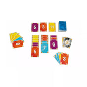 A Bango társasjáték minden eleme egy képen: színes számozott kártyák, a kártyapakli, a doboz és a játékosok kezei. A kép tökéletesen visszaadja a játék lendületes, vidám és családbarát hangulatát.