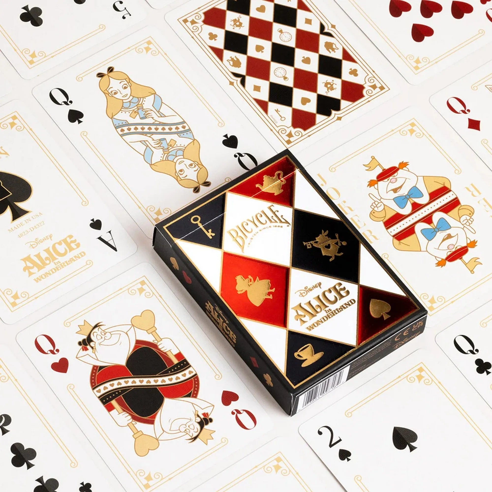 A Bicycle Disney Alice in Wonderland kártyapakli doboza elölről látható, körülötte az Alice Csodaországban szereplőit ábrázoló, díszes kártyalapokkal.