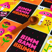 A Bimm Bamm Brumm! társasjáték vidám gombás kártyái és fa kanalai részletes közeli fotón.
