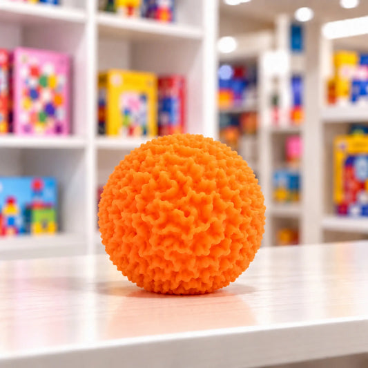 Cool Mix Squishy: Bolyhos tapintású labda 6 cm stresszlevezető játék (narancssárga), élénk narancssárga, rücskös felületű labda játékbolt pultján.