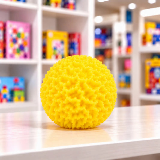 Cool Mix Squishy: Bolyhos tapintású labda 6 cm stresszlevezető játék (sárga), élénksárga, rücskös felületű labda játékbolt pultján.