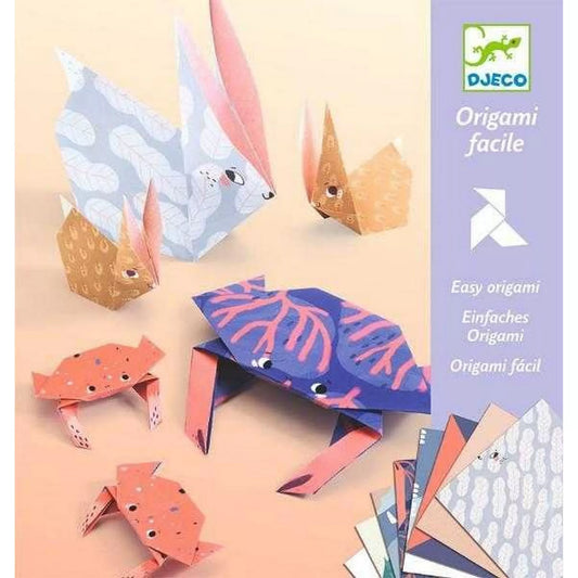 „A Djeco Origami – Állatcsaládok készlet bemutatóképe nyulakkal és rákokkal: többféle színű és mintájú, előre nyomtatott origamilapokból hajtogatott állatok – nagy és kis nyuszik rózsaszín és kék mintákkal, valamint két korallszínű rák figura – egymás mellett elhelyezve.”