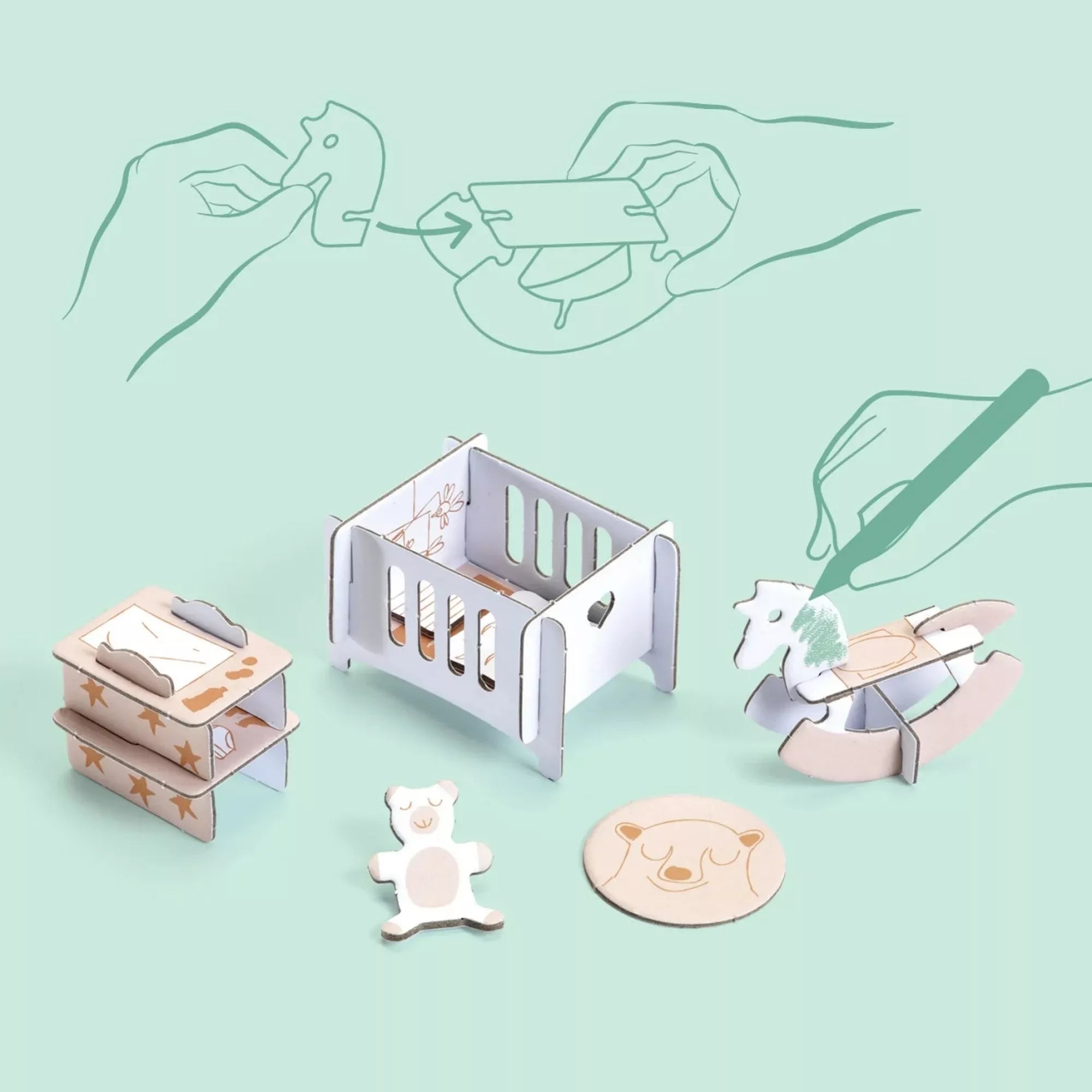 Karton bútorok közelről: kiságy, hintaló, polcok és medvefigurás kiegészítők. A háttér rajzolt útmutatóval mutatja, hogyan illeszthetők össze az elemek, illetve hogyan lehet kiszínezni őket.