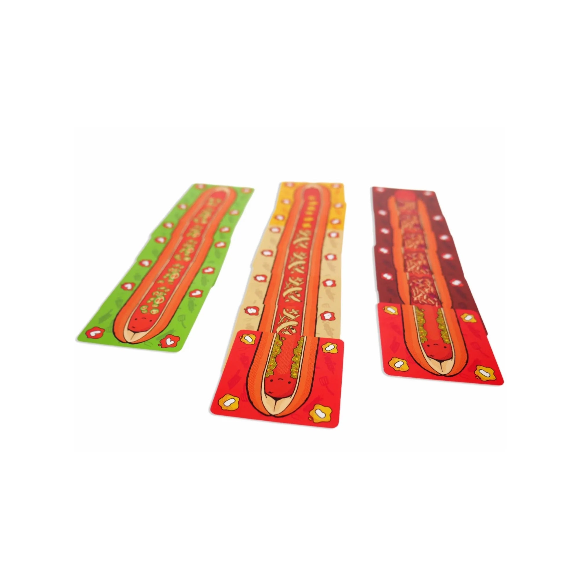 Három különböző színű hot dog kártyasor a Hoddog társasjátékból, zöld, sárga és barna háttérrel.
