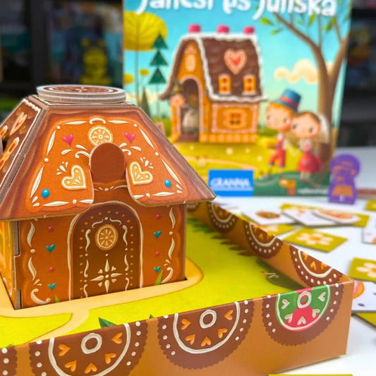Jancsi és Juliska társasjáték 3D mézeskalács házikója közelről, háttérben a játék dobozával