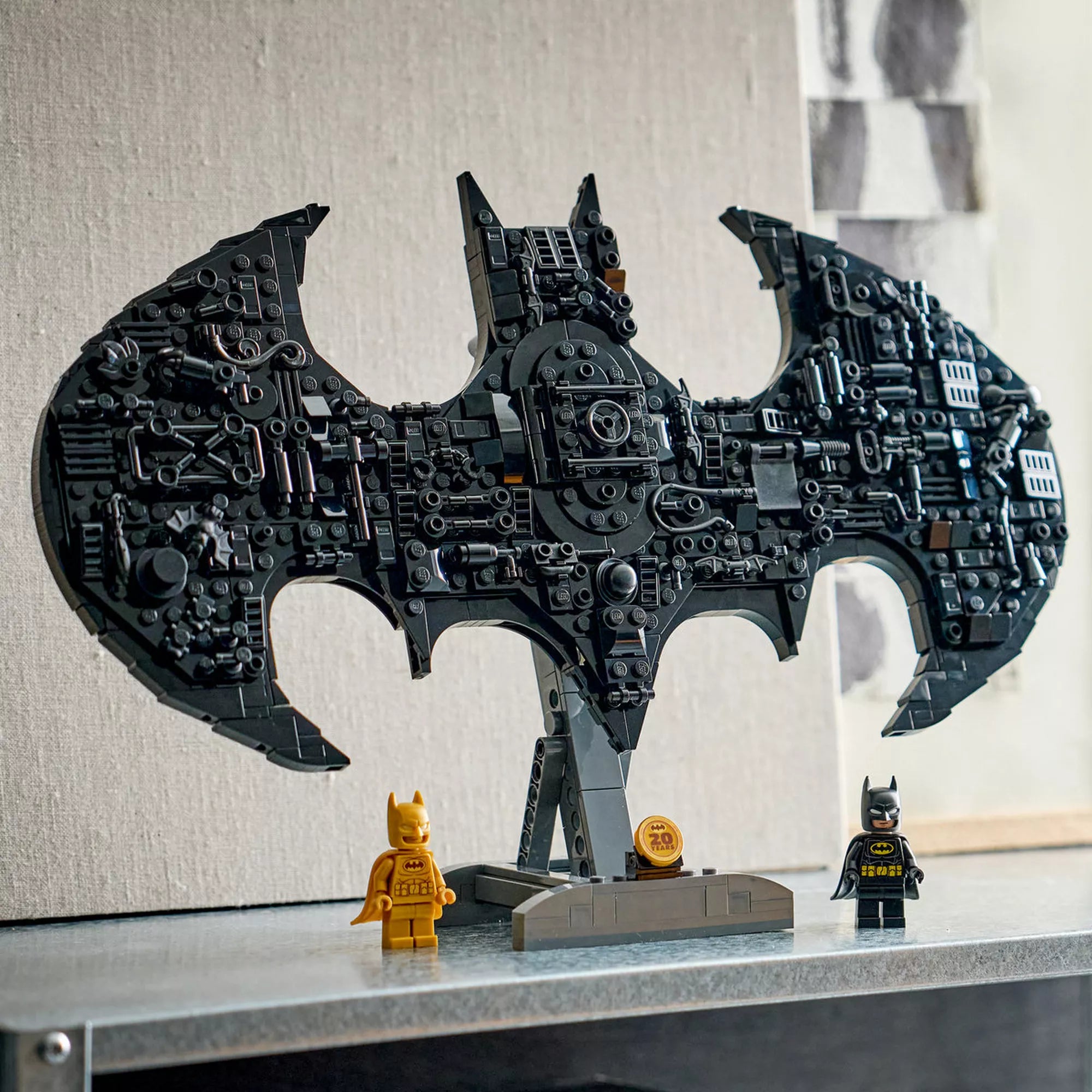 LEGO DC Batman logó 76330 kész modell polcon kiállítva, Batman és arany Batman minifigurával.