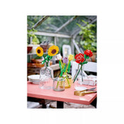 LEGO Botanicals virágok összeállítása különböző LEGO virágkészletekkel egy asztalon vázákban elrendezve