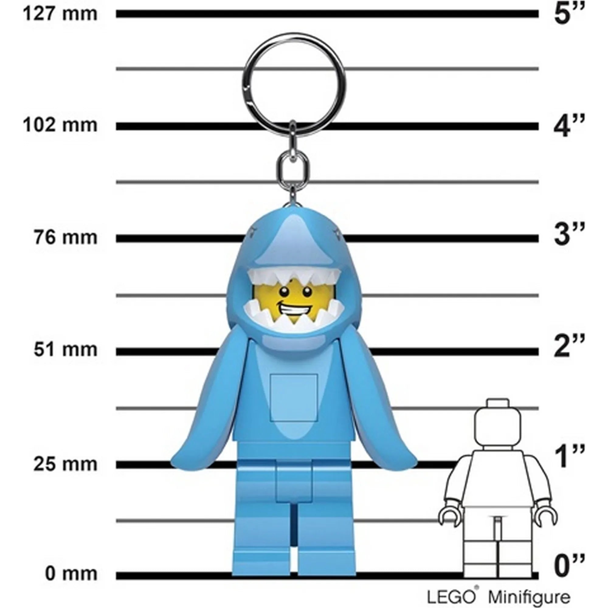A képen a LEGO LED Shark Guy kulcstartó látható méretarányos háttér előtt, centiméter- és inch-skálával. A kulcstartó minifigura nagyobb, mint egy hagyományos LEGO minifigura.