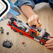 LEGO City F1 kamion játék közben, Audi versenyautó a szállítóplatformon és minifigurák a vezetőfülkében.