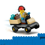 LEGO City repülőtéri poggyászszállító kocsi repülőtéri dolgozó minifigurával. A kis jármű csomagokat és bőröndöket szállít a repülőgéphez, miközben a dolgozó védősisakot és hallásvédőt visel.