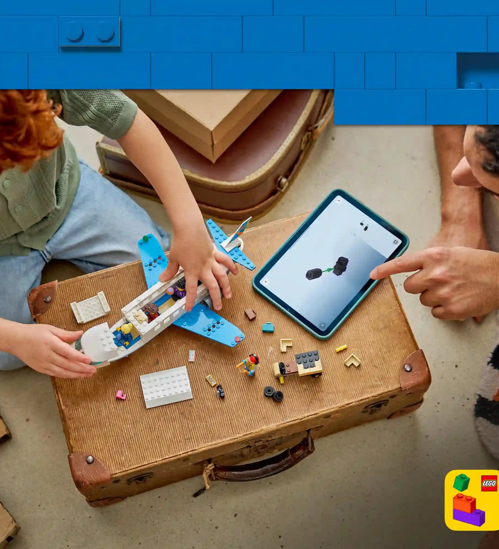 Gyermek és felnőtt együtt építi a LEGO City Utasszállító repülőgép modellt, miközben a LEGO Builder alkalmazás digitális 3D-s útmutatója segíti az építést.