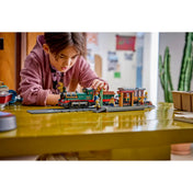 Gyermek játék közben a LEGO City Veterán gőzvonat 60511 modellel, részletgazdag állomással és klasszikus vasúti szerelvénnyel.
