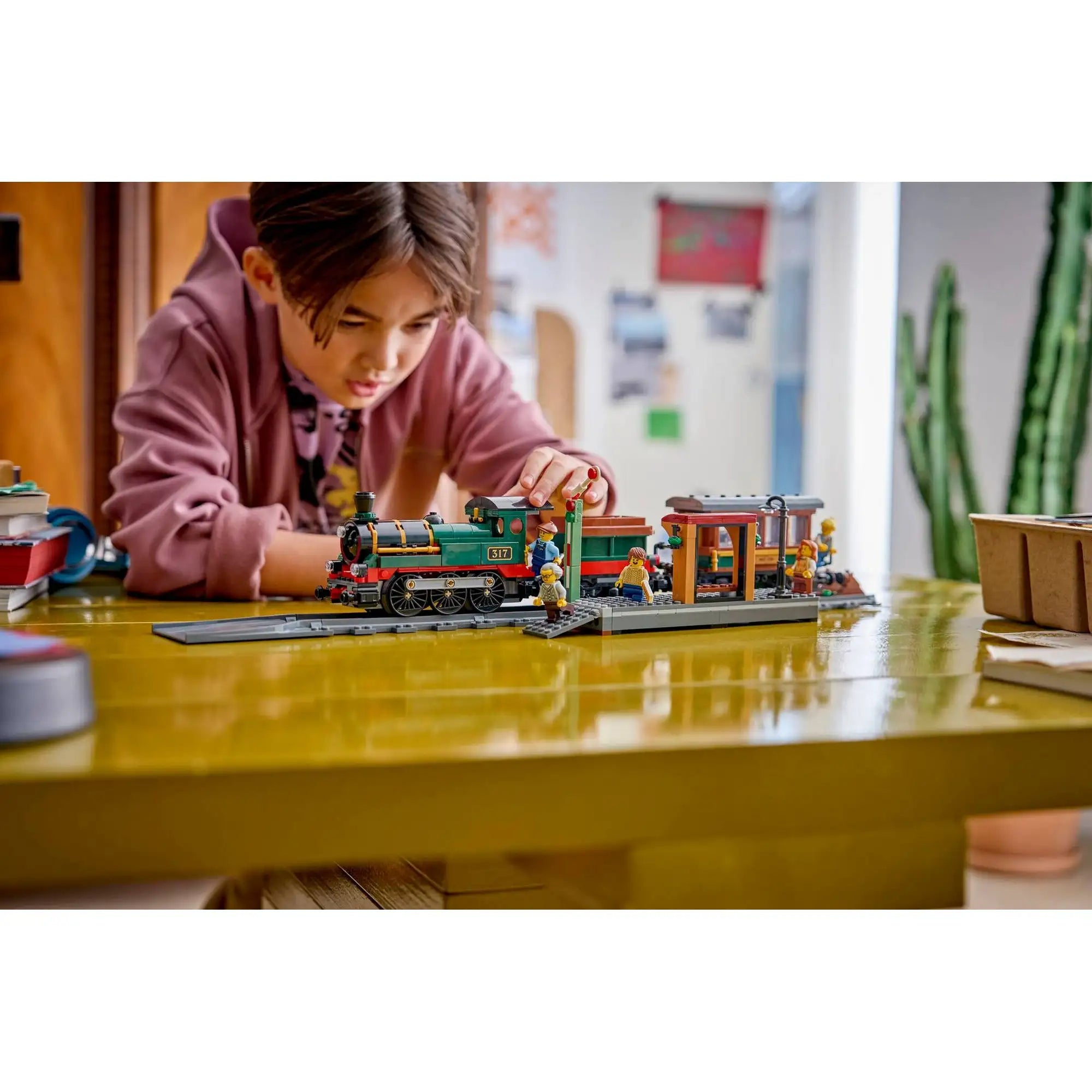 Gyermek játék közben a LEGO City Veterán gőzvonat 60511 modellel, részletgazdag állomással és klasszikus vasúti szerelvénnyel.