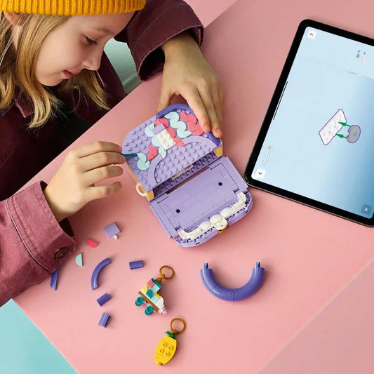 Gyermek építi és testre szabja a LEGO Creator Dekorálható táska modellt, miközben a LEGO Builder alkalmazás digitális útmutatóját használja egy tableten.