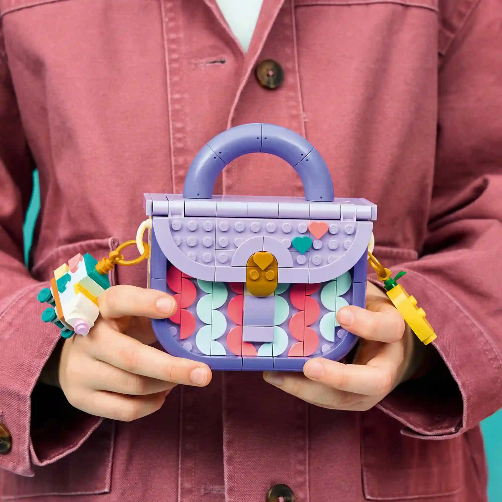 Kézben tartott LEGO Creator Dekorálható táska modell lila fogantyúval, színes kulcstartókkal és dekoratív szív mintás elemekkel