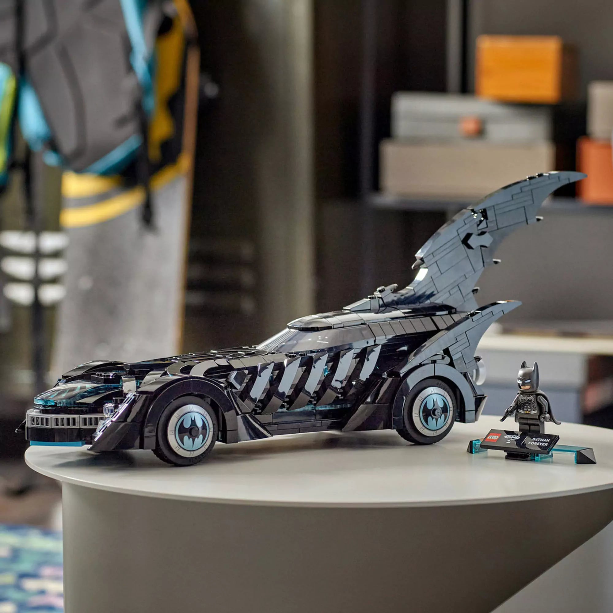 LEGO DC Super Heroes: Mindörökké Batman Batmobile (76304) kiállítva asztalon, a mellékelt Batman minifigurával együtt.